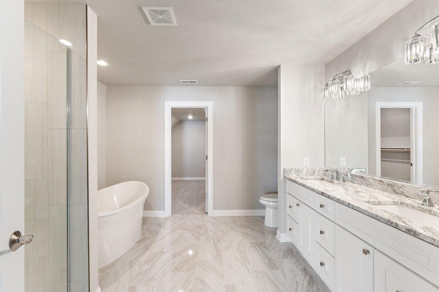 3090 West 105th Avenue Crown Point, IN 46307 - Photo 17 of 22 a bathroom with a granite countertop sink a toilet and a large mirror