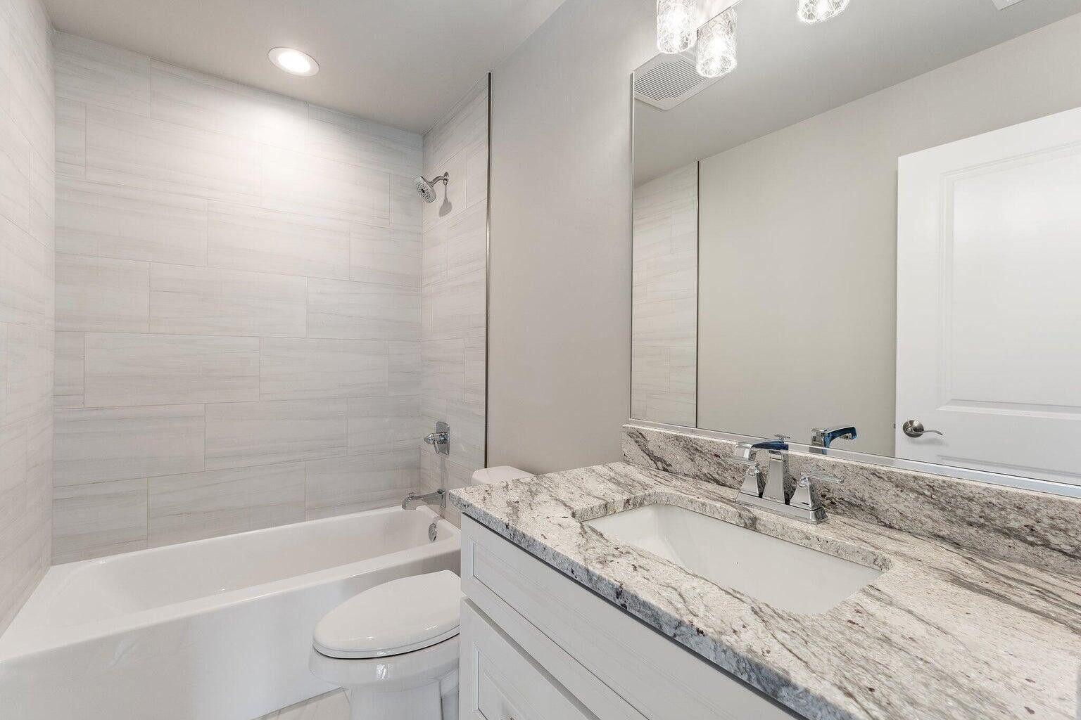 3090 West 105th Avenue Crown Point, IN 46307 - Photo 19 of 22 a bathroom with a granite countertop sink a toilet and bathtub