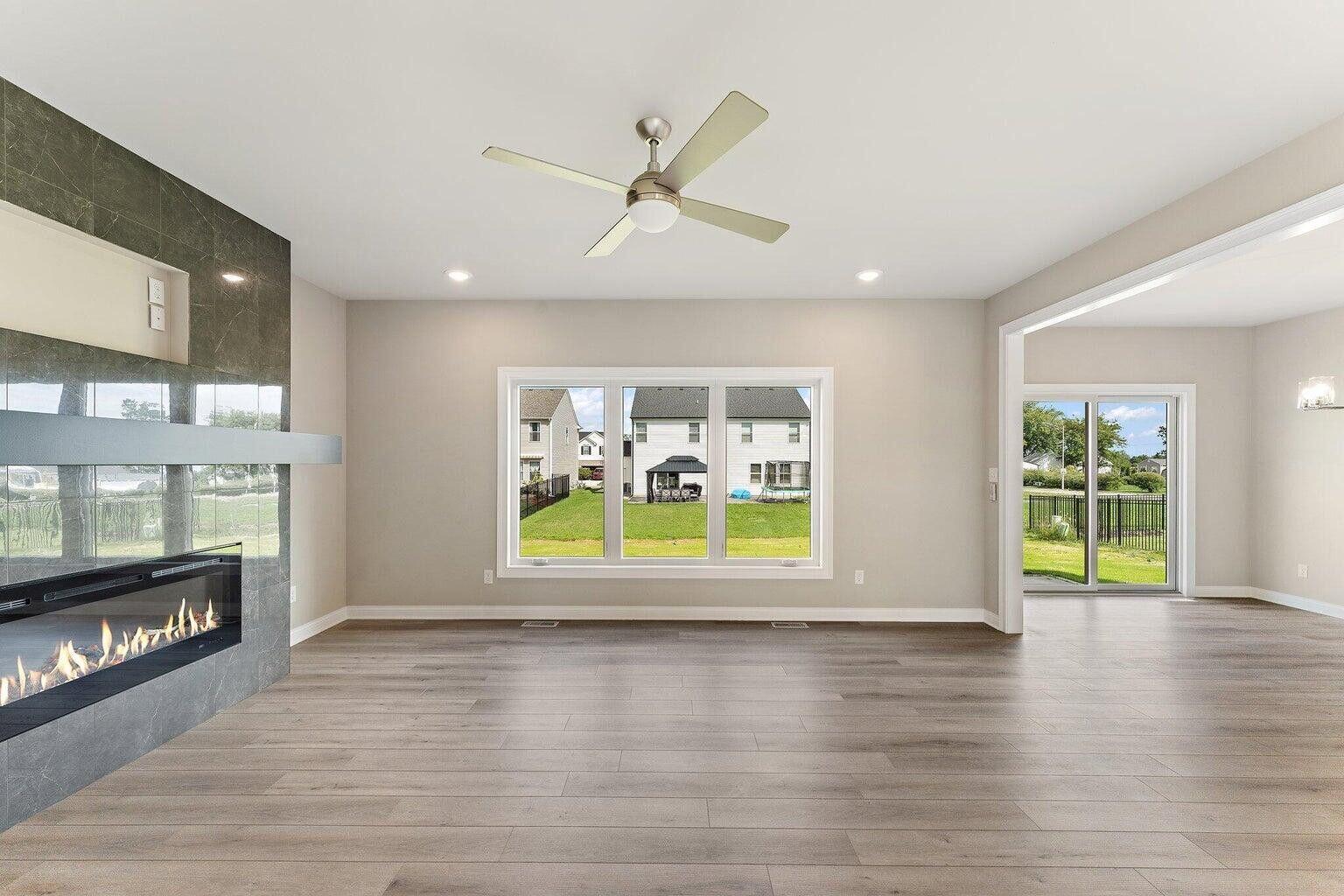 3090 West 105th Avenue Crown Point, IN 46307 - Photo 9 of 22 a view of an empty room with a window and wooden floor