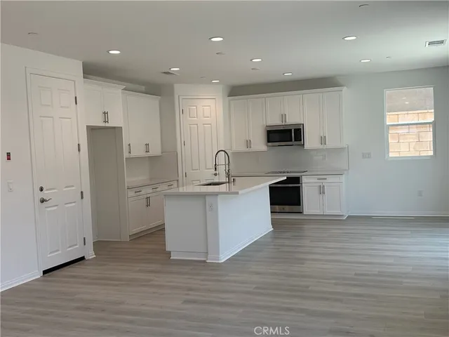 a kitchen with white cabinets and stainless steel appliances