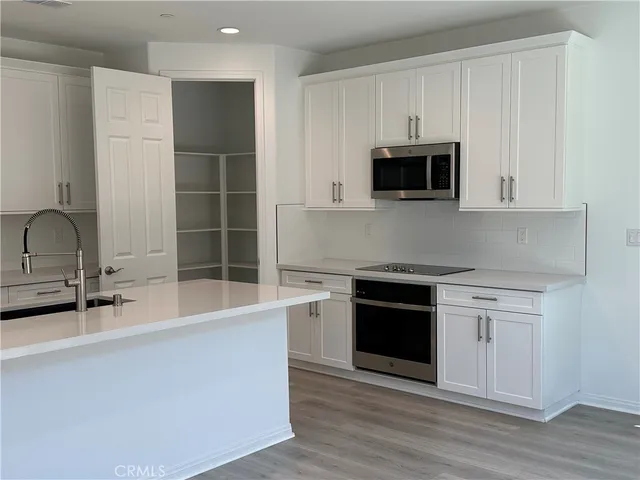 a kitchen with stainless steel appliances a stove a microwave and sink
