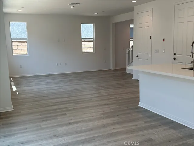 a view of a kitchen with wooden floor and a sink
