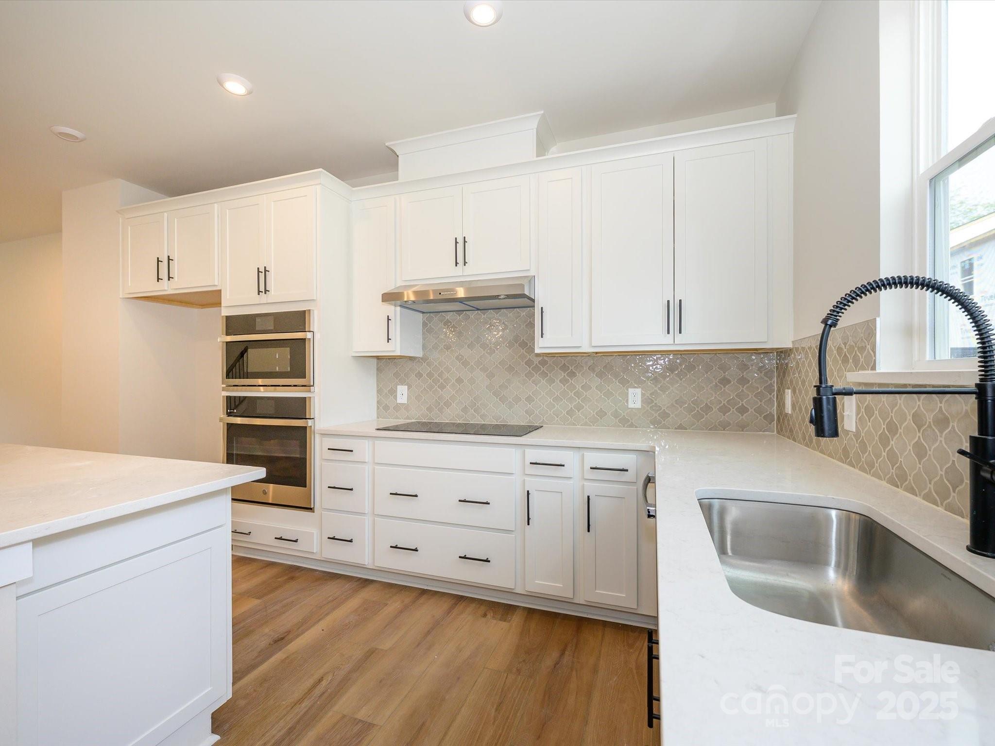 6009 Pivot Court Charlotte, NC 28205 - Photo 5 of 16 a kitchen with granite countertop white cabinets and white appliances