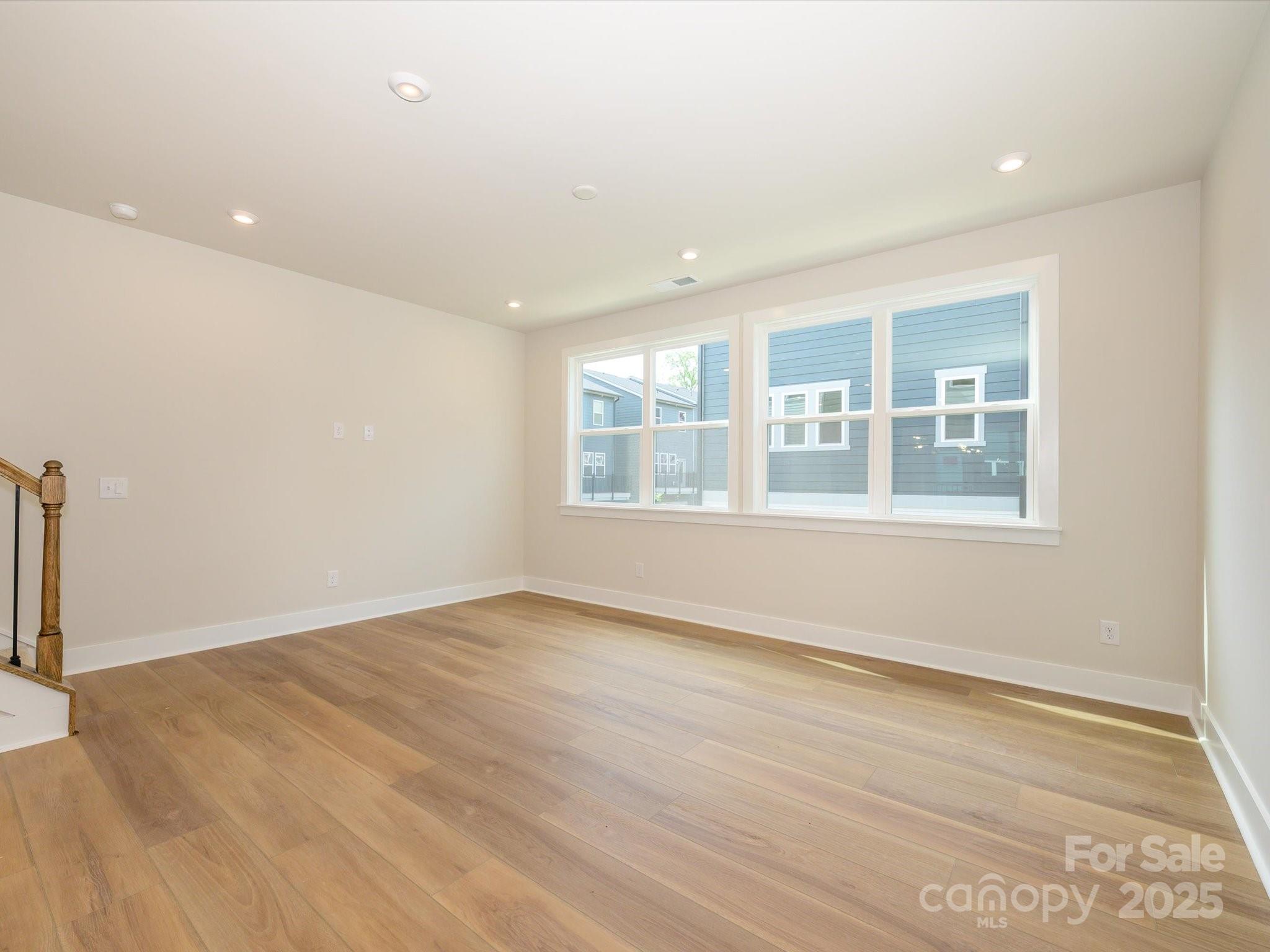 6009 Pivot Court Charlotte, NC 28205 - Photo 7 of 16 an empty room with wooden floor and windows