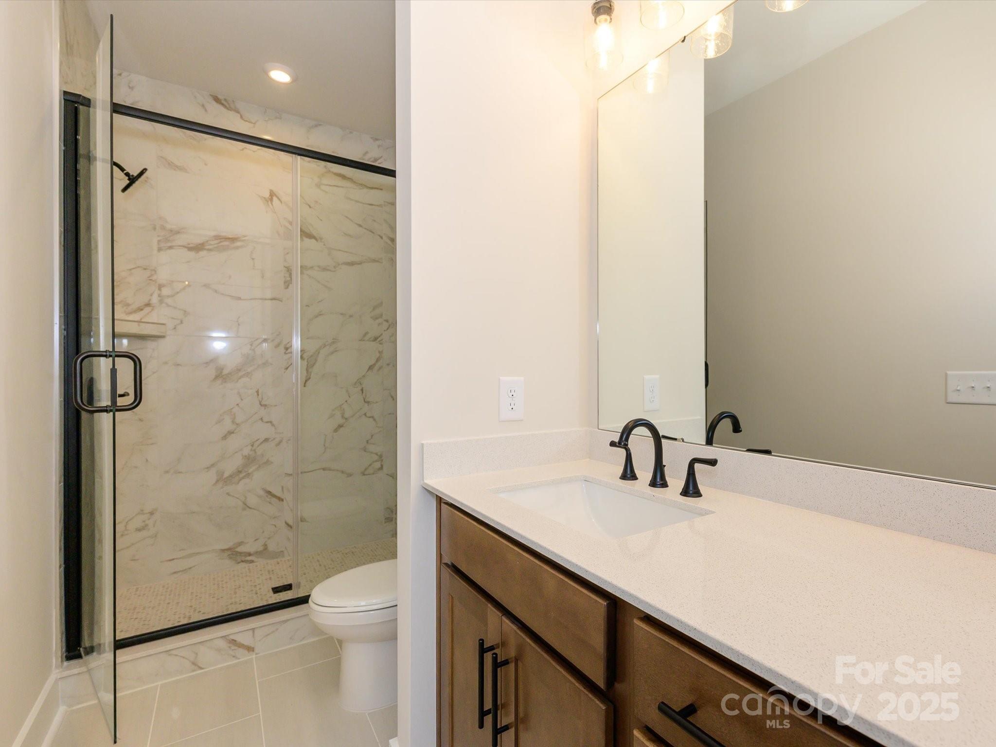 6009 Pivot Court Charlotte, NC 28205 - Photo 10 of 16 a bathroom with a shower sink vanity mirror and toilet
