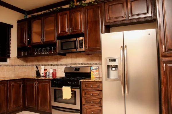 a kitchen with stainless steel appliances granite countertop a refrigerator and a stove top oven