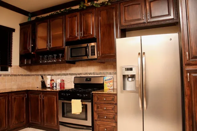 a kitchen with stainless steel appliances granite countertop a refrigerator and a stove top oven