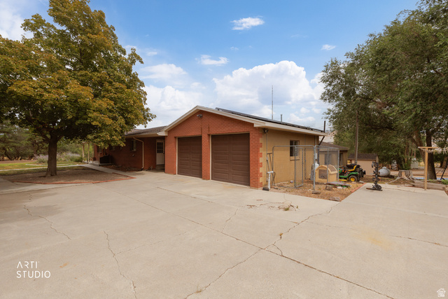 16535 South Redwood Road Riverton, UT 84065 - Photo 3 of 59 Property exterior featuring a two-car garage with individual doors, a concrete driveway, and mature trees