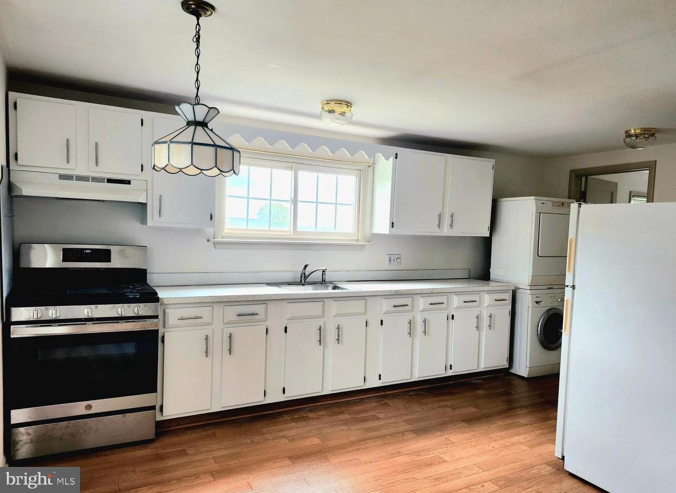 22 Wayne Avenue Trooper, PA 19403 - Photo 2 of 13 a kitchen with granite countertop white cabinets white stainless steel appliances and wooden floors