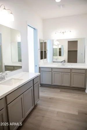 a bathroom with a double vanity sink mirror and bathtub