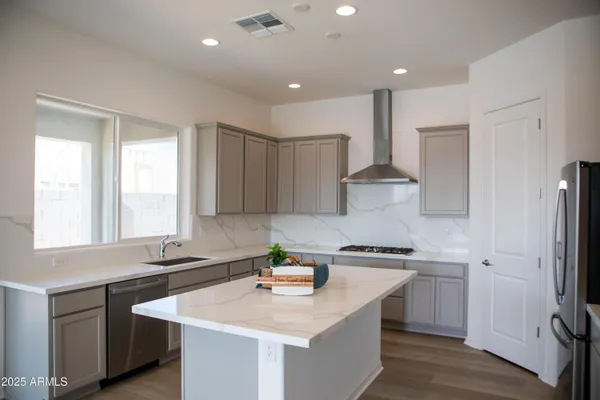 a kitchen with stainless steel appliances granite countertop a sink stove and refrigerator