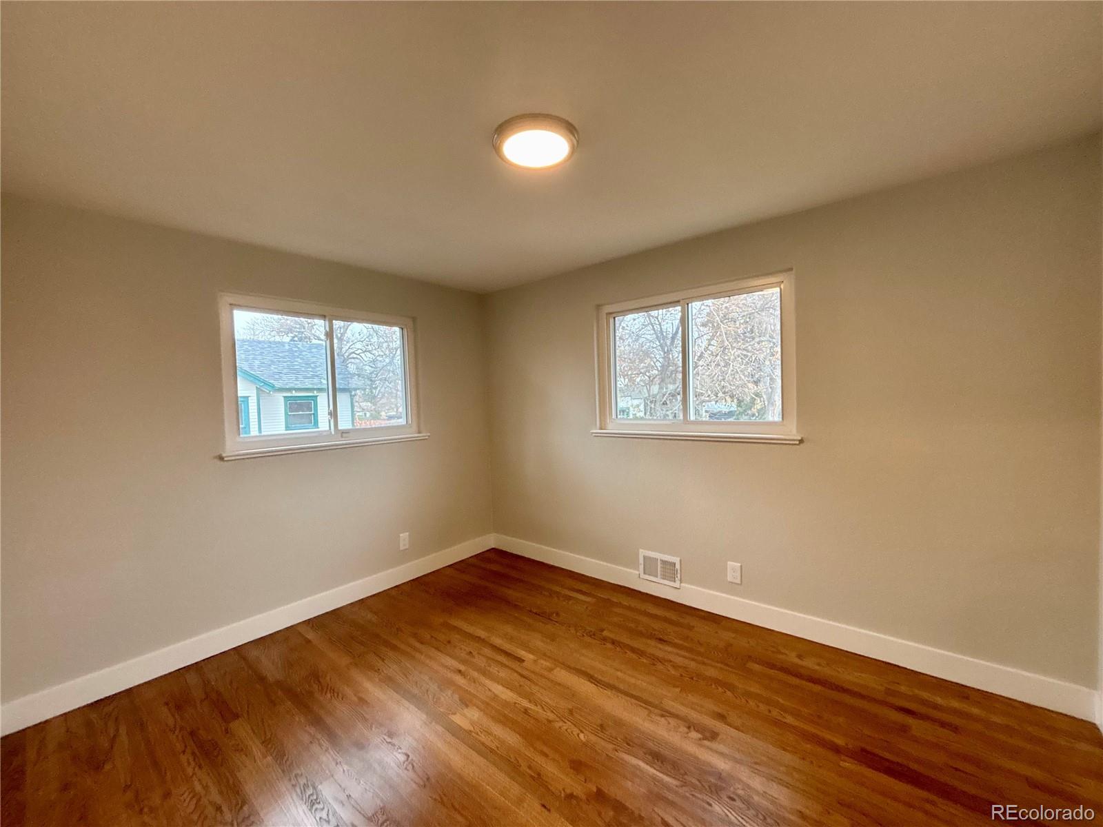 4420 Teller Street Wheat Ridge, CO 80033 - Photo 11 of 20 a view of a room with wooden floor and windows