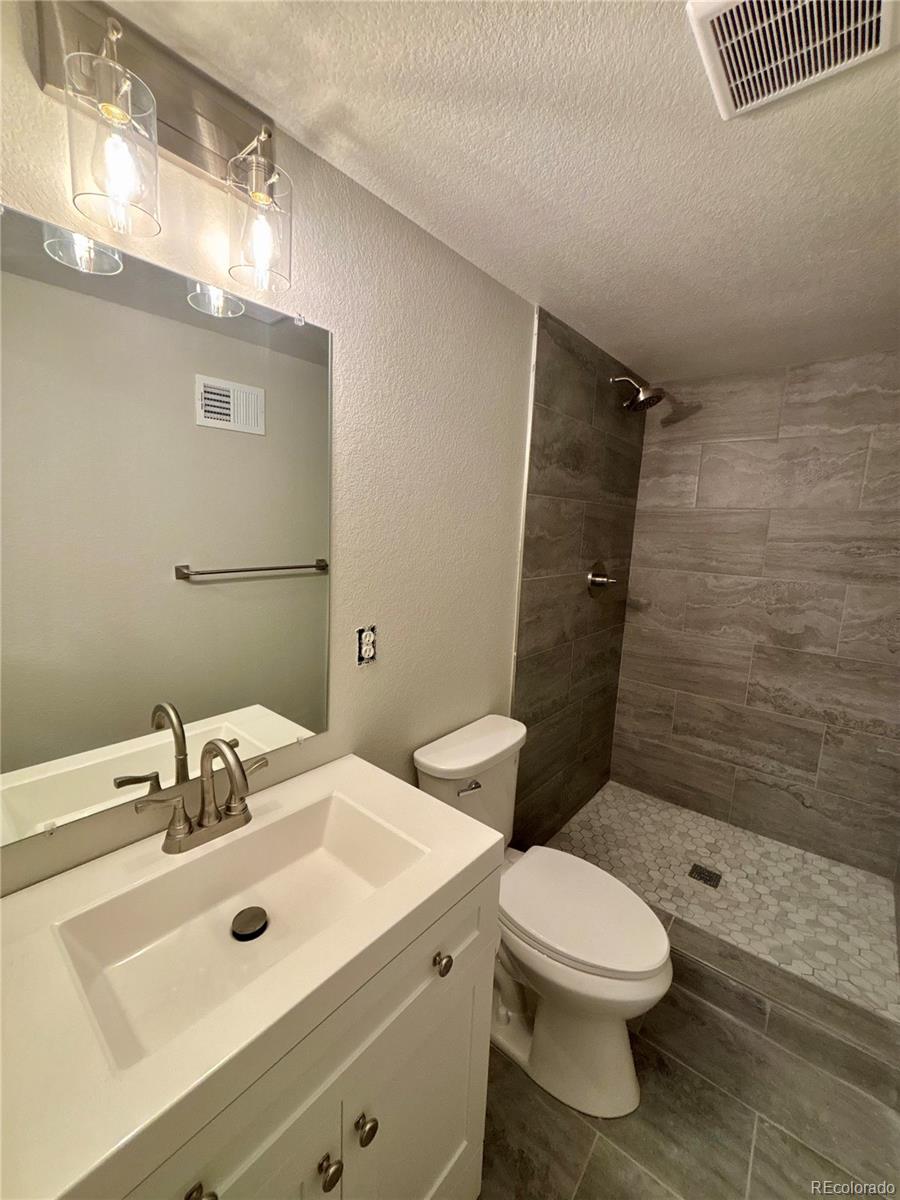4420 Teller Street Wheat Ridge, CO 80033 - Photo 15 of 20 a bathroom with a sink mirror vanity and toilet