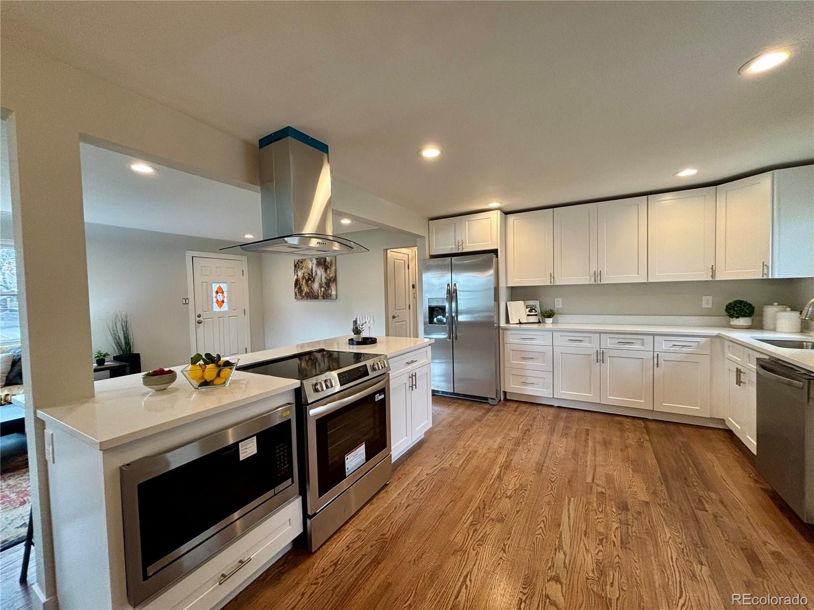 4420 Teller Street Wheat Ridge, CO 80033 - Photo 5 of 20 a kitchen with granite countertop a stove top oven and cabinets