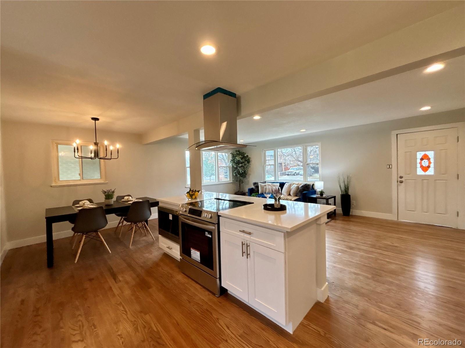 4420 Teller Street Wheat Ridge, CO 80033 - Photo 7 of 20 a open kitchen with stainless steel appliances granite countertop a stove and cabinets with wooden floor