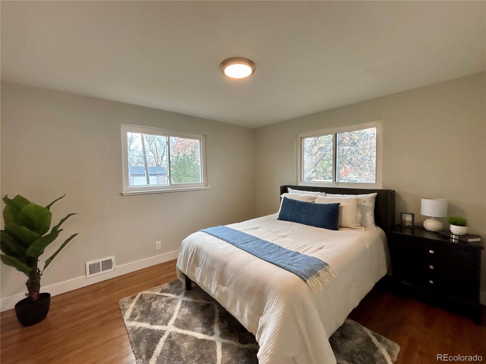 4420 Teller Street Wheat Ridge, CO 80033 - Photo 9 of 20 a bedroom with a bed and a potted plant