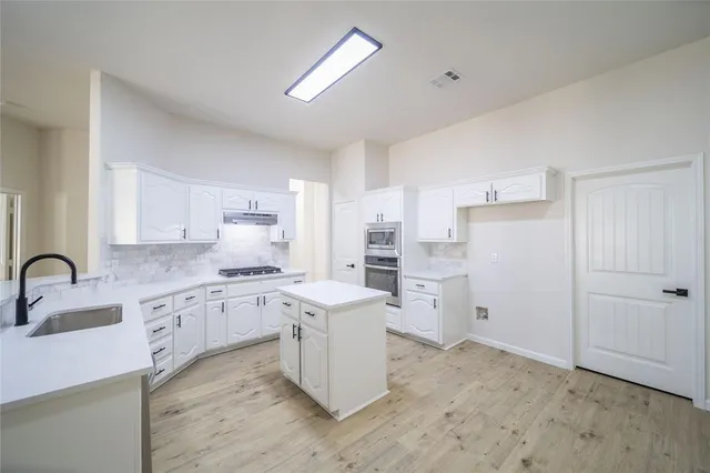 a kitchen with white cabinets and white appliances