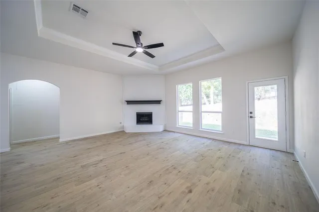 a view of an empty room with a fireplace and a window