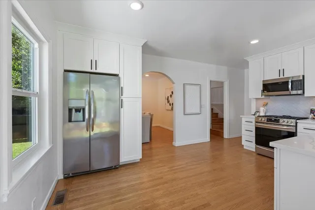 a kitchen with stainless steel appliances granite countertop a refrigerator and a stove top oven