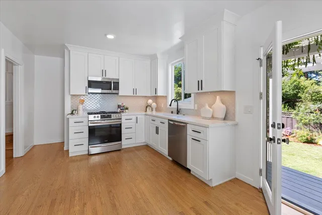 a kitchen with white cabinets and white appliances