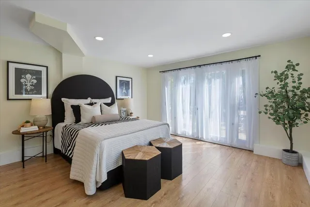 a spacious bedroom with a bed and a potted plant