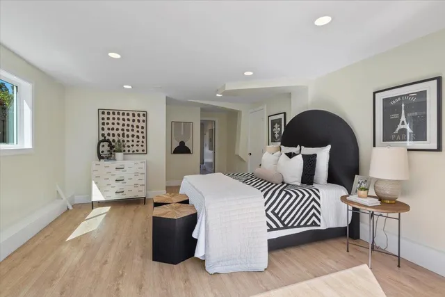 a bedroom with a bed and wooden floor