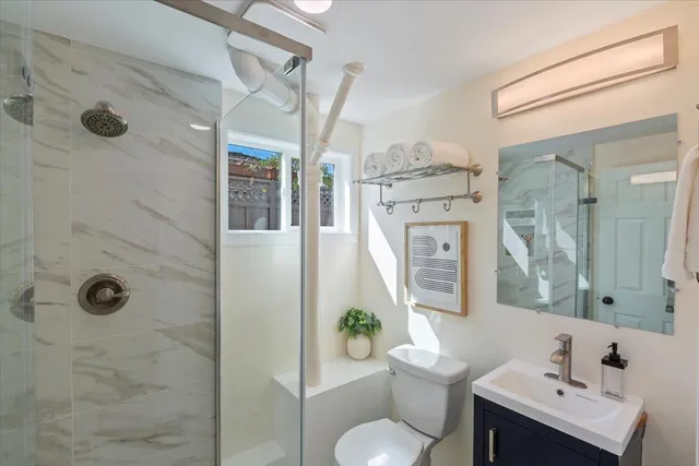 a bathroom with a sink toilet a mirror and shower