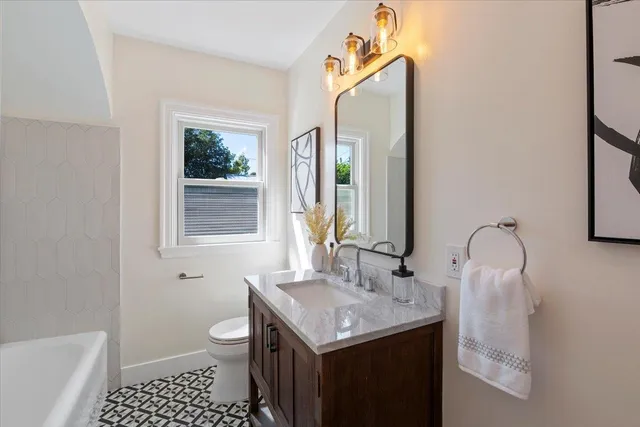 a bathroom with a granite countertop sink toilet and shower