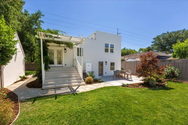 a view of a house with backyard and sitting area