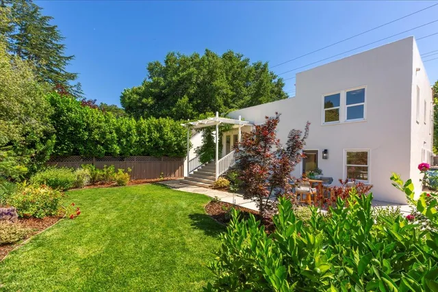 a backyard of a house with table and chairs