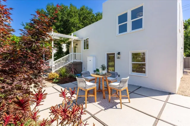 a view of a patio with table and chairs potted plants with wooden fence