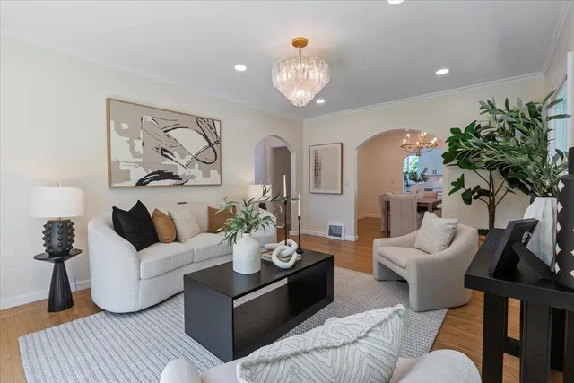 a living room with furniture and a chandelier