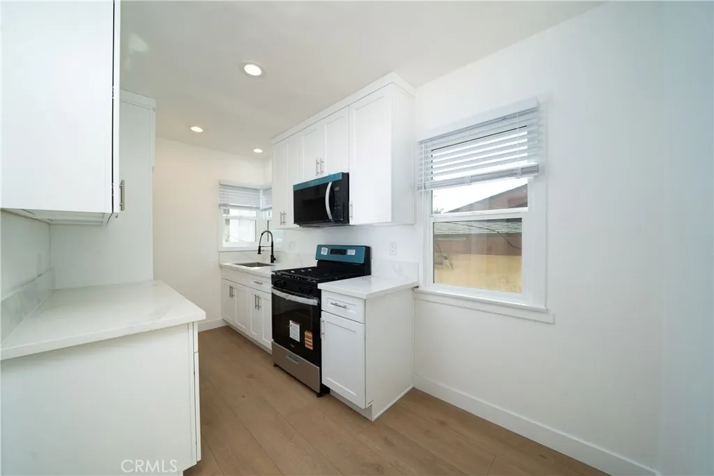 1050 Cedar Avenue Long Beach, CA 90813 - Photo 4 of 8 a kitchen with a stove a sink and a microwave