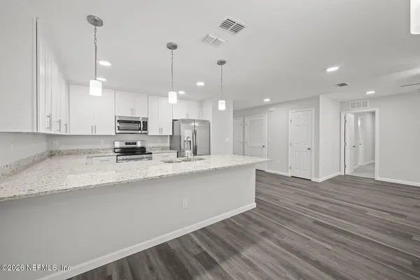 a kitchen with a refrigerator sink and cabinets