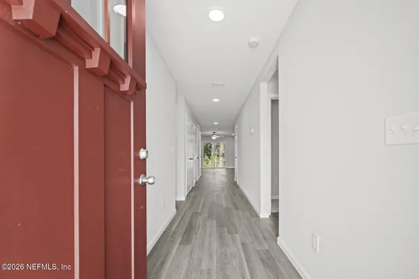a view of a hallway with wooden floor