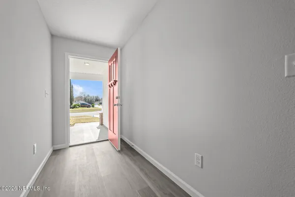 a view of a hallway with wooden floor