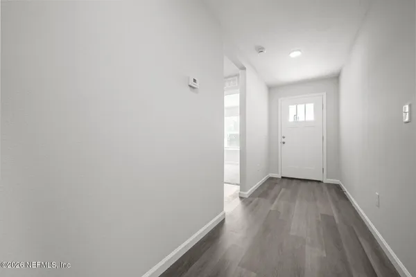a large kitchen with a center island wooden floor stainless steel appliances and a window