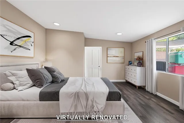 a bedroom with a bed painting on wall and a large window