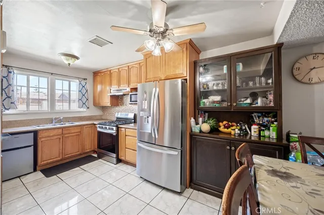 a kitchen with granite countertop stainless steel appliances a sink counter space and a window