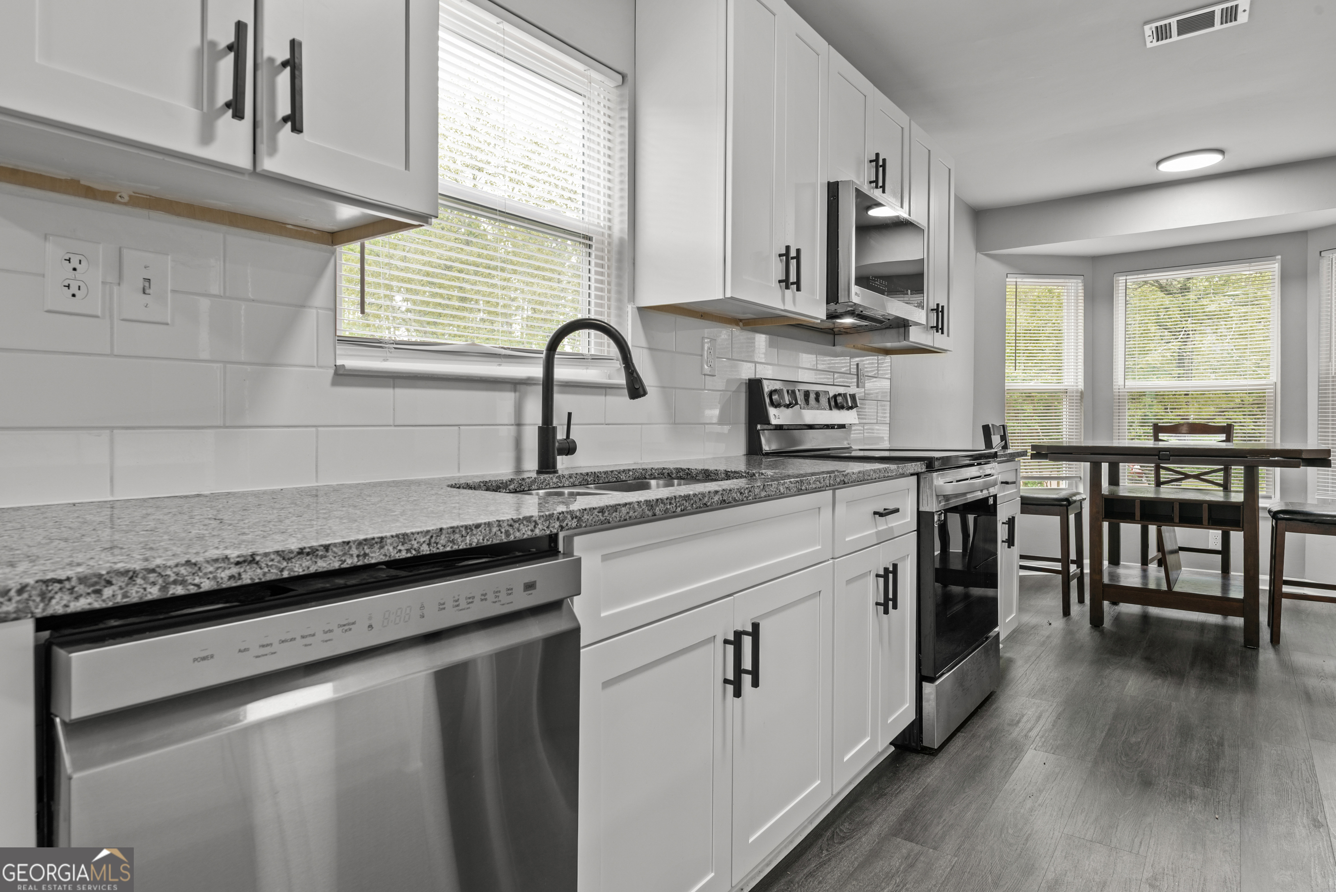 140 Cumberland Court Athens, GA 30607 - Photo 6 of 19 a kitchen with stainless steel appliances granite countertop hardwood floor sink stove dining table and chairs