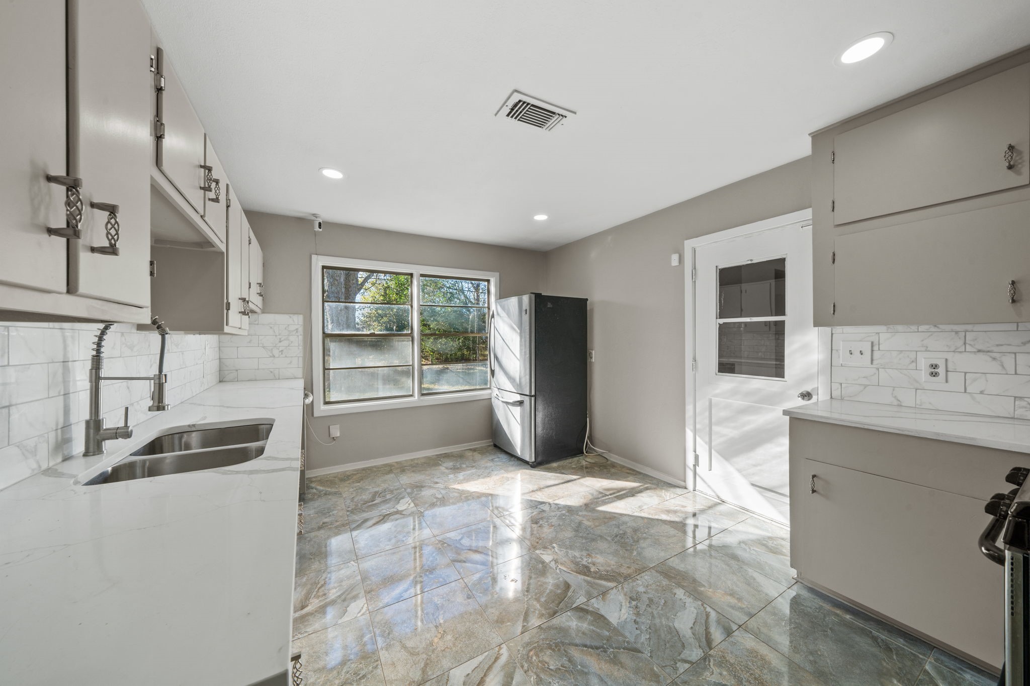 4110 Friar Point Road Houston, TX 77047 - Photo 3 of 15 a view of a kitchen with a sink and dishwasher a refrigerator with white cabinets
