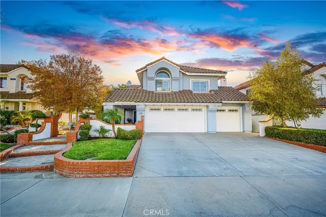 a front view of a house with a garden and yard