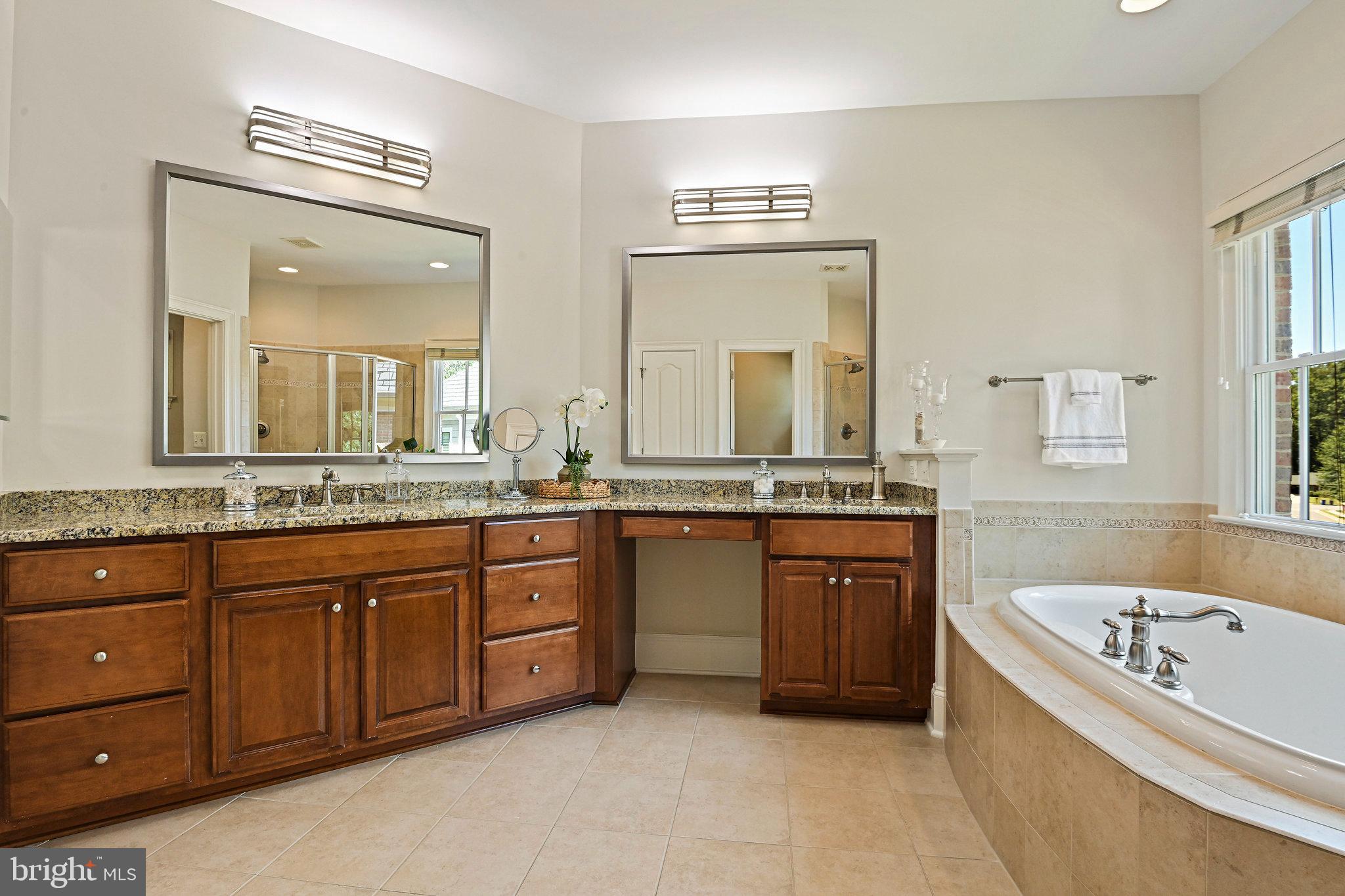 8424 Falcone Pointe Way Vienna, VA 22182 - Photo 49 of 71 a spacious bathroom with a granite countertop tub sink and mirror