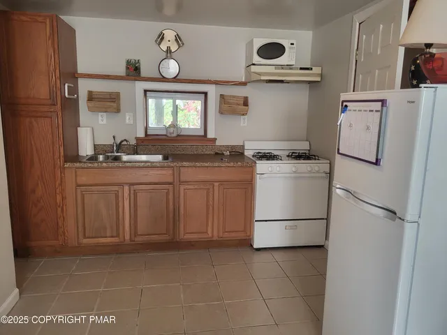 a kitchen with a stove top oven cabinets and a refrigerator
