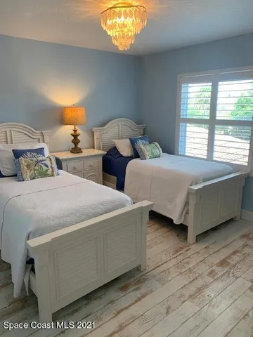 a bedroom with two beds and painting on the wall