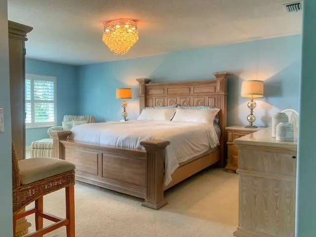 a bedroom with a bed and a chandelier