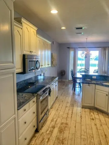 a large kitchen with stainless steel appliances granite countertop a stove and a sink