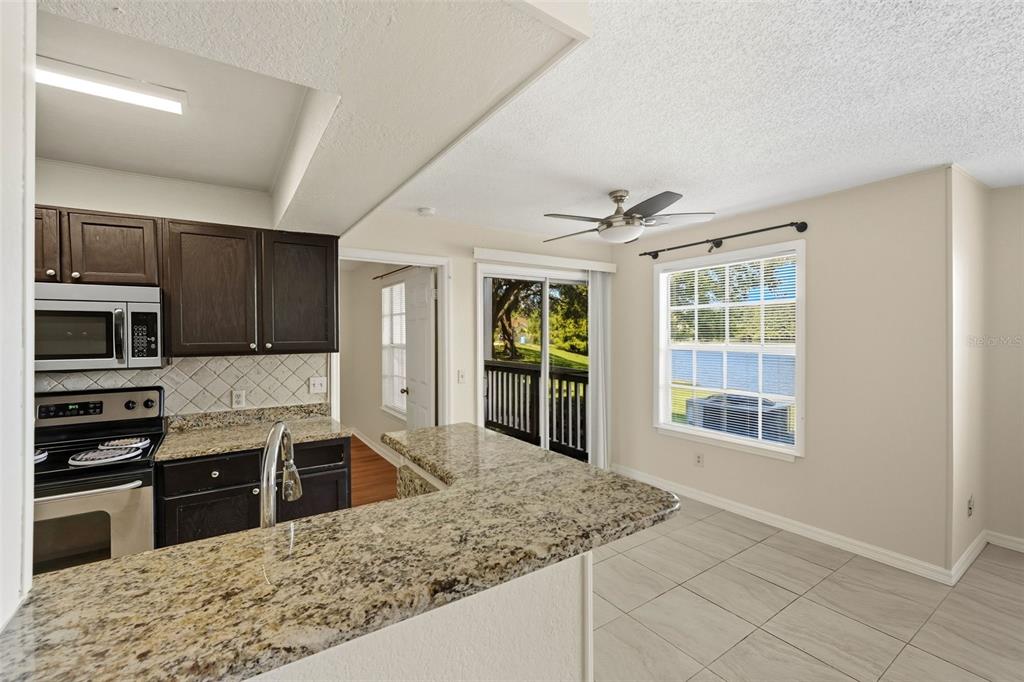 1039 South Hiawassee Road, Unit 2918 Orlando, FL 32835 - Photo 11 of 28 a kitchen with stainless steel appliances granite countertop a sink stove and refrigerator