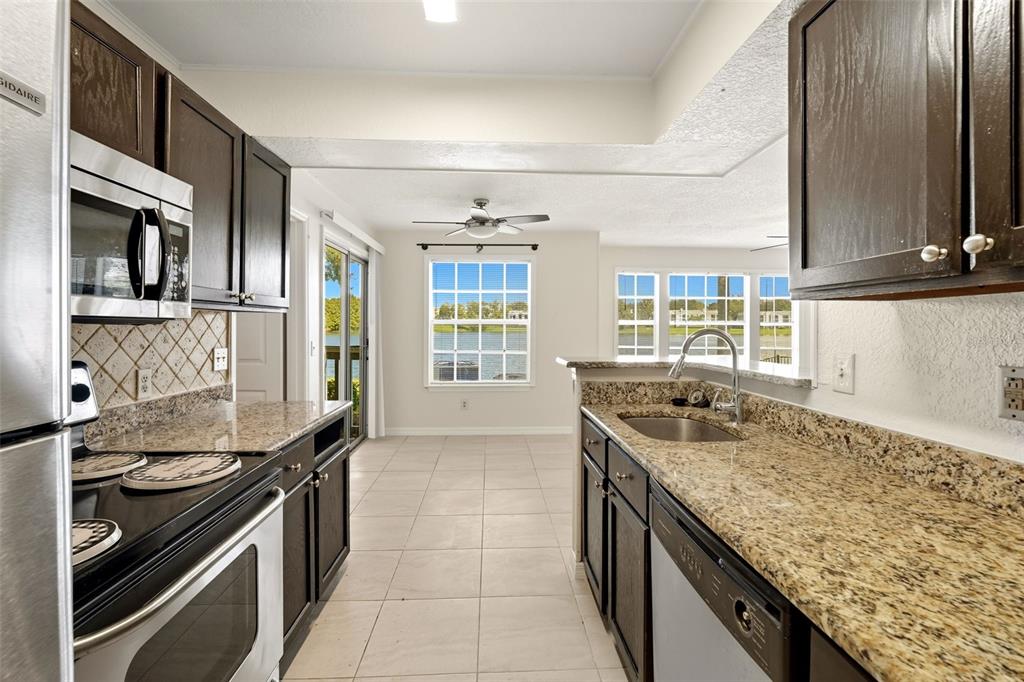 1039 South Hiawassee Road, Unit 2918 Orlando, FL 32835 - Photo 15 of 28 a kitchen with granite countertop stainless steel appliances a sink stove and cabinets