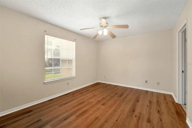 a bathroom with a granite countertop sink a toilet a mirror a vanity a bathtub and shower